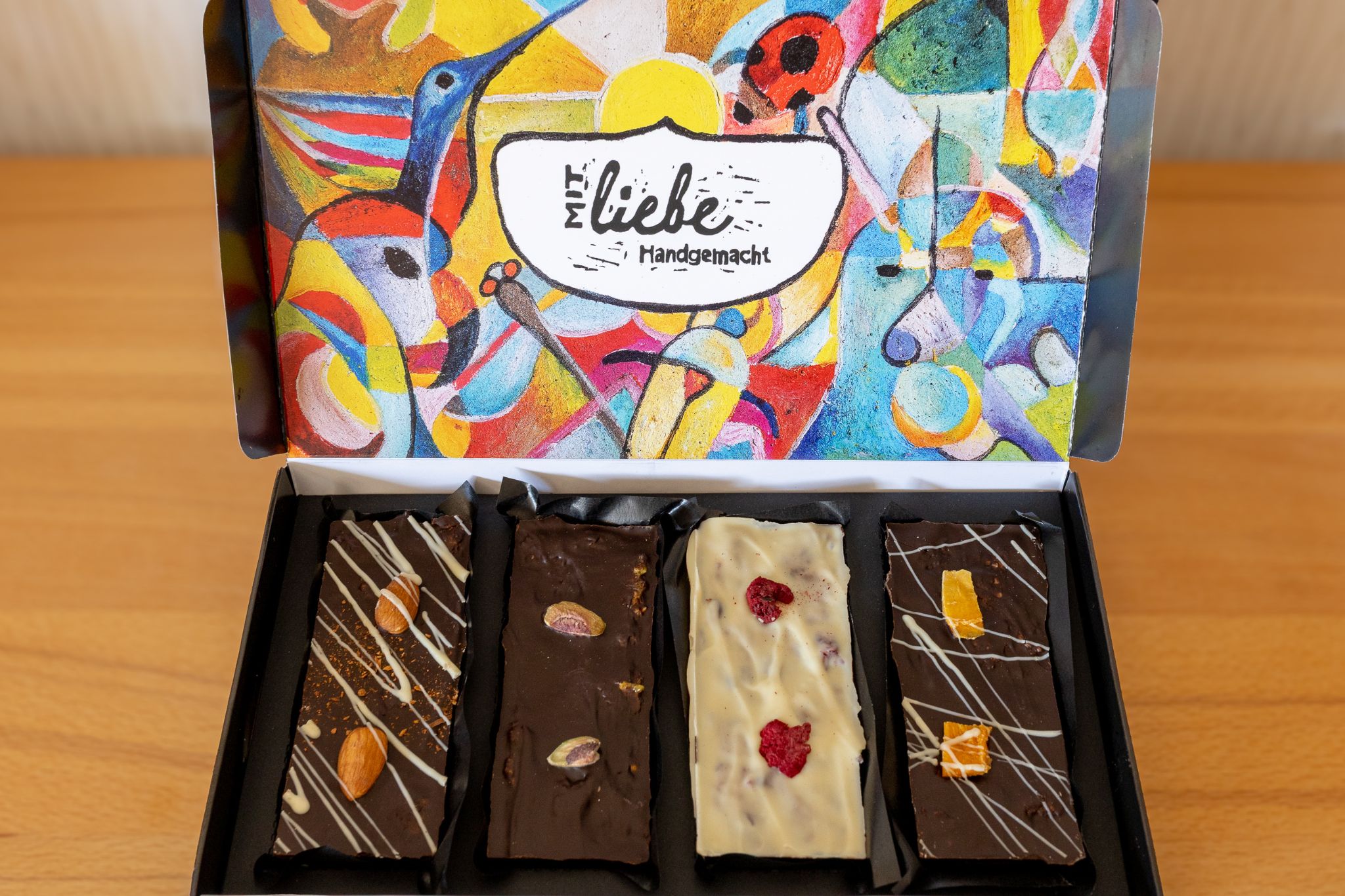Geöffnete 4er-Schokoladenbox von Lilly’s Chocolaterie mit vier handgemachten Tafeln in unterschiedlichen Sorten